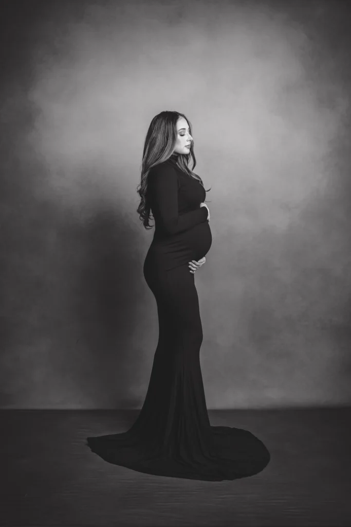 Maternity photoshoot in studio. Pregnant mom posing for camera. Photoshoot in san antonio. Black maternity gown.