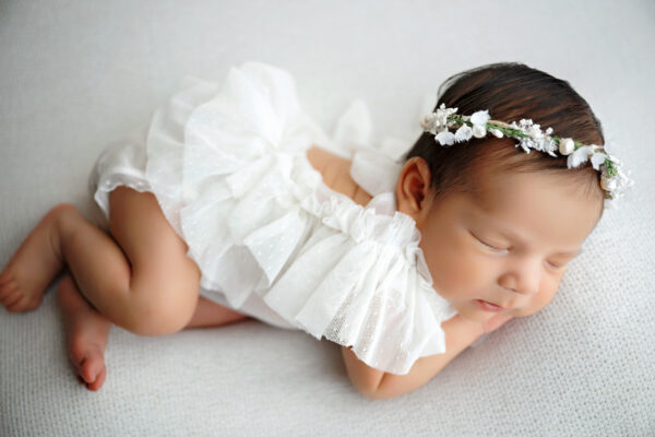 San Antonio newborn photographer captures sleeping baby girl in white outfit.