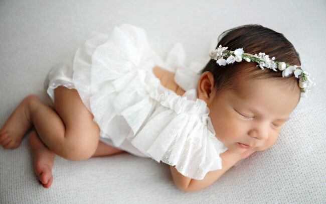 San Antonio newborn photographer captures sleeping baby girl in white outfit.