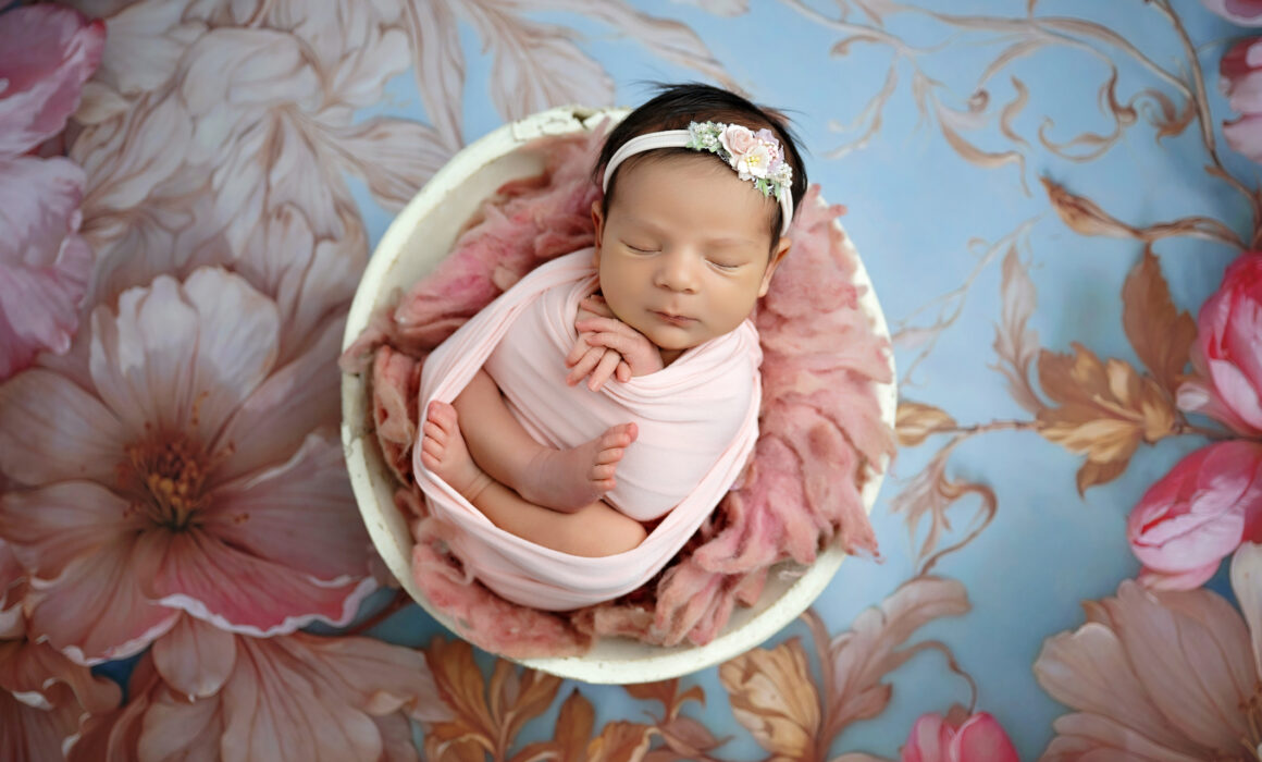 San Antonio newborn photographer captures sleeping newborn baby curled up in pose in a prop