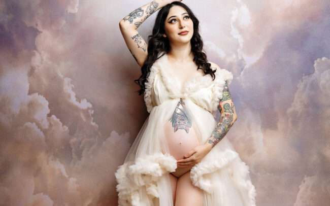 Dreamy cloud backdrop maternity session in ivory gown