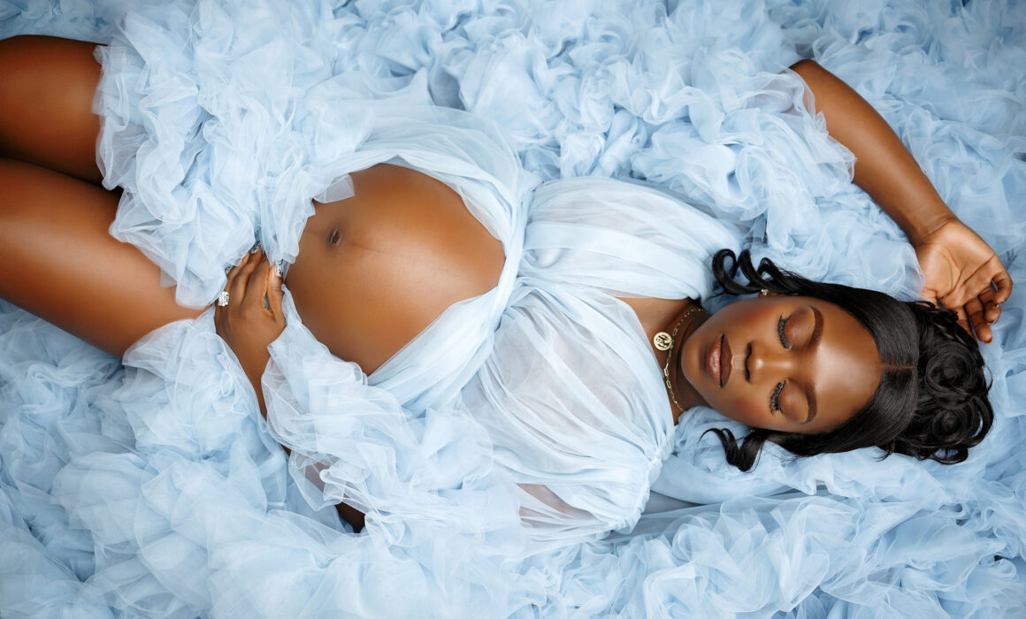 San Antonio maternity photographer studio session with expecting mother in blue tulle gown and spouse on blue backdrop