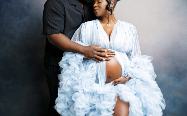 San Antonio maternity photographer studio session with expecting mother in blue tulle gown and spouse on blue backdrop