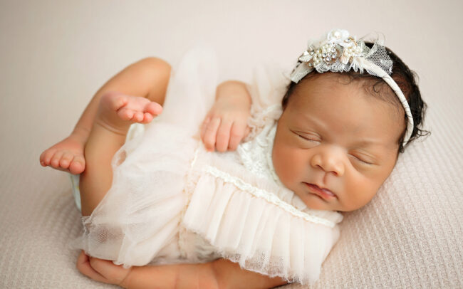 Baby girl wrapped in dusty rose with flowers during San Antonio newborn photo session
