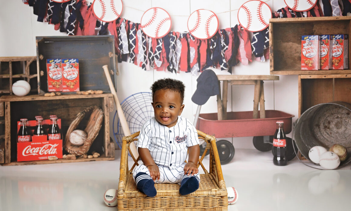 8-month-old baby smiling in a baseball-themed milestone photography setup in San Antonio