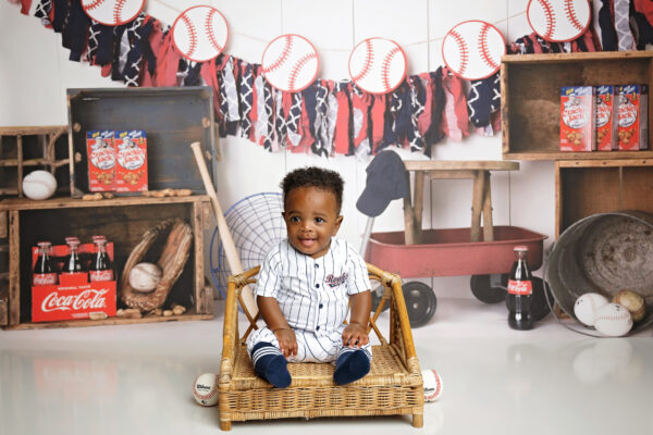 8-month-old baby smiling in a baseball-themed milestone photography setup in San Antonio