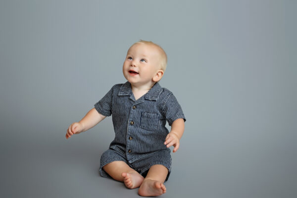 Smiling baby in a blue outfit during a simple classic San Antonio milestone photography session