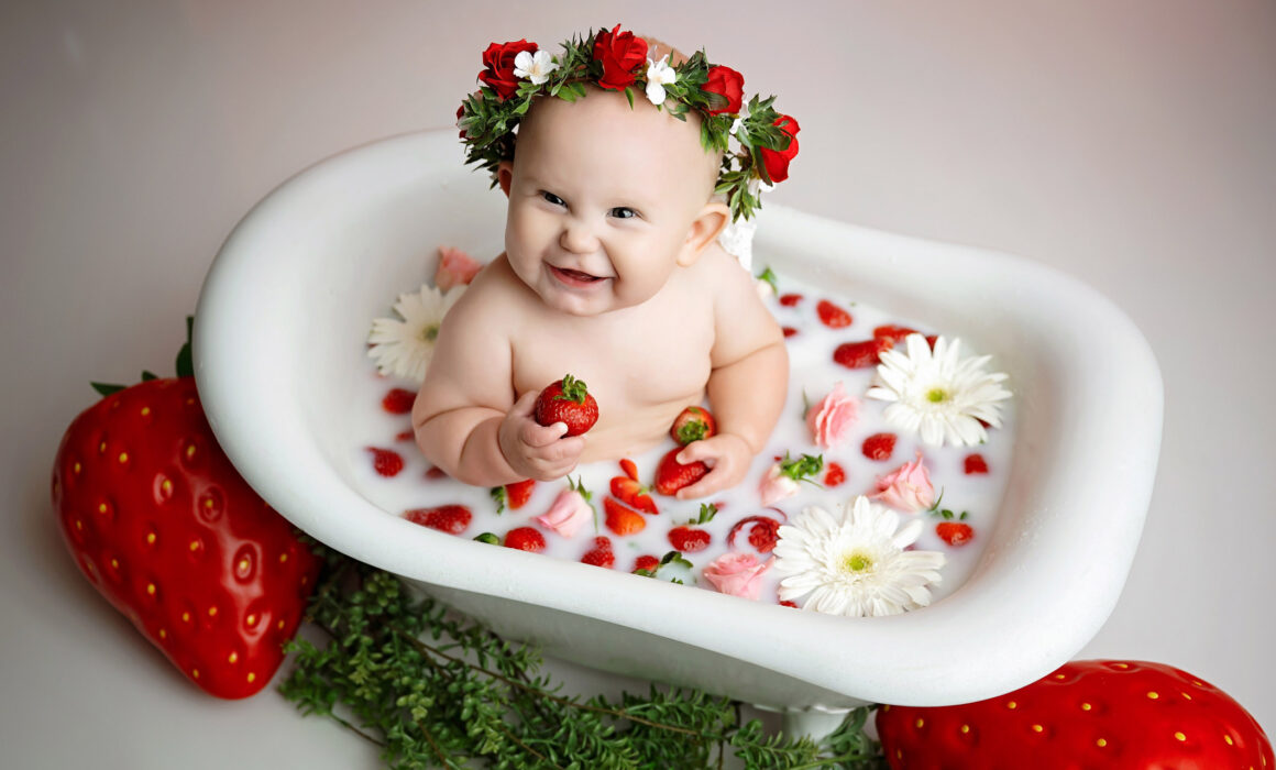 9 month old baby enjoying a strawberry milk bath during her San Antonio milestone photography session