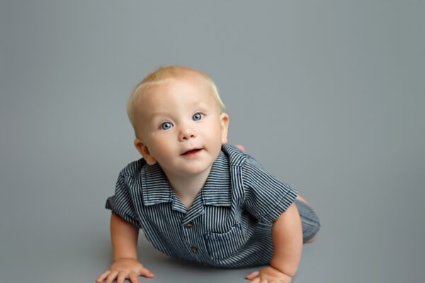 Baby crawling toward the camera during a timeless studio milestone photography session in San Antonio