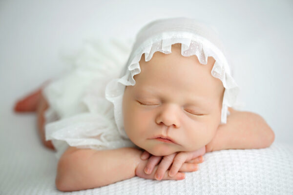 Baby girl posed in soft white and neutral tones during a San Antonio newborn photography session