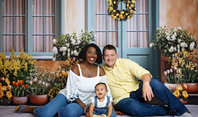 family portrait with grandparents, daughter, son-in-law and baby girl against a romantic floral backdrop