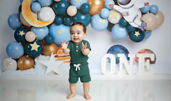 Smiling baby boy during an outer space first birthday cake smash session in San Antonio