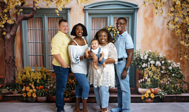Three generations of family smiling together in a spring garden-inspired studio portrait