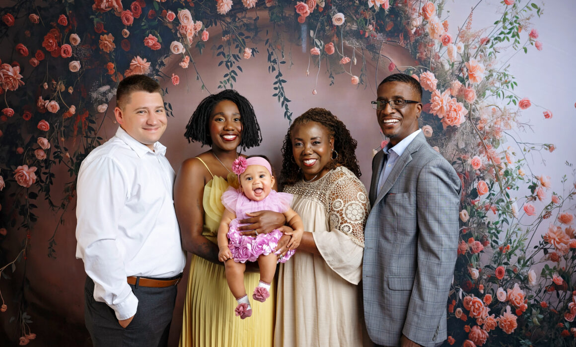 Three-generation family portrait with grandparents, parents and baby in a floral San Antonio photography studio