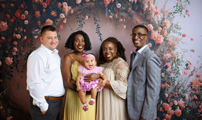 Three-generation family portrait with grandparents, parents and baby in a floral San Antonio photography studio