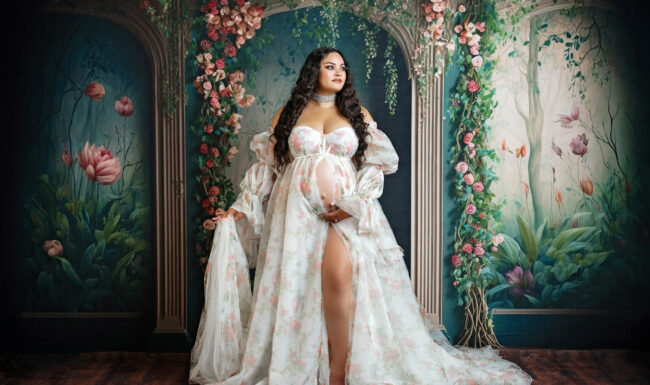 Pregnant mom wearing a floral maternity gown during a petite studio maternity session in San Antonio