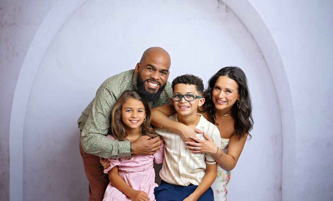 Expecting parents smiling with their son and daughter during a San Antonio studio maternity session