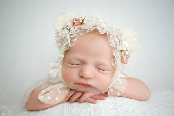 Sleeping newborn baby girl wearing a cream floral teddy bear bonnet during her San Antonio newborn photography session.
 Copy



2. Curled-Up Baby Pose