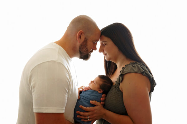 Smiling family of six posing with their newborn baby boy in a San Antonio photography studio.